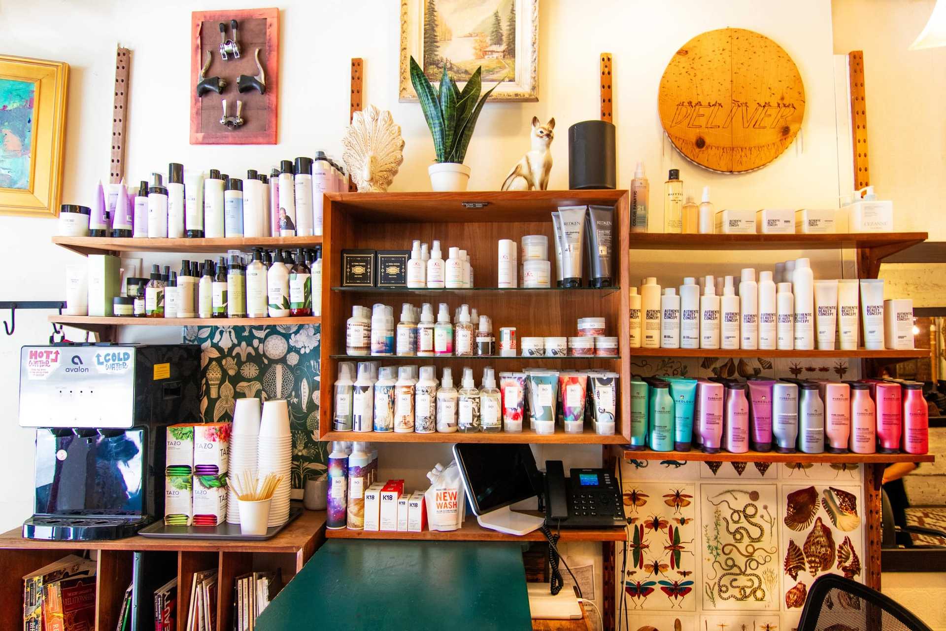 Salon interior with colorful hair products and artful decor on shelves.